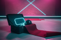 Open black soft-shell trunk with props spilling out on concrete warehouse floor with magenta-cyan stage lighting